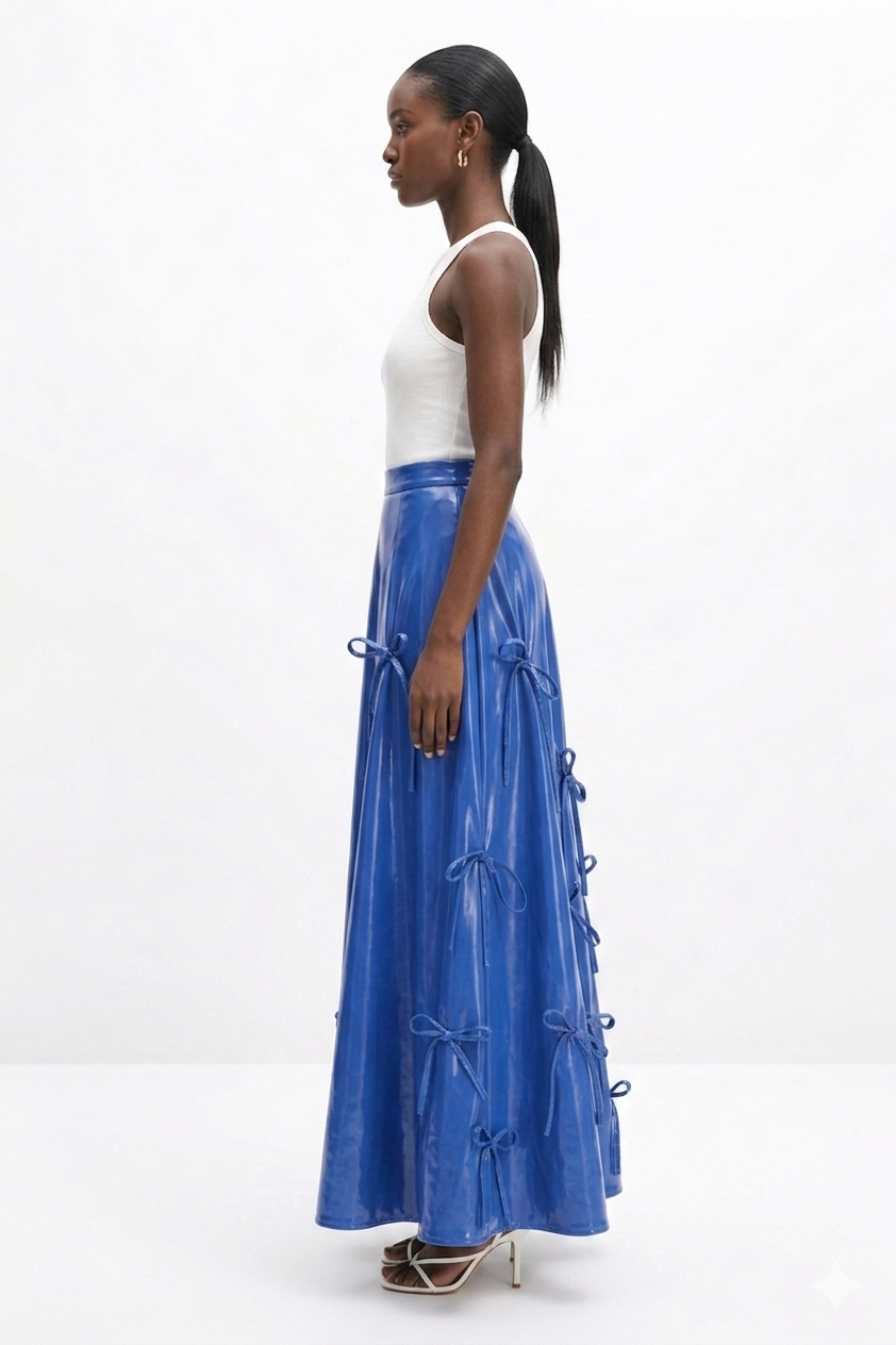 Woman wearing a white top and blue  KINGDOM OF DAUGHTERS skirt on a white background
