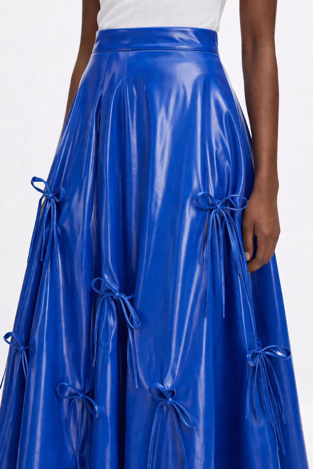 Woman wearing a white top and blue  KINGDOM OF DAUGHTERS skirt on a white background