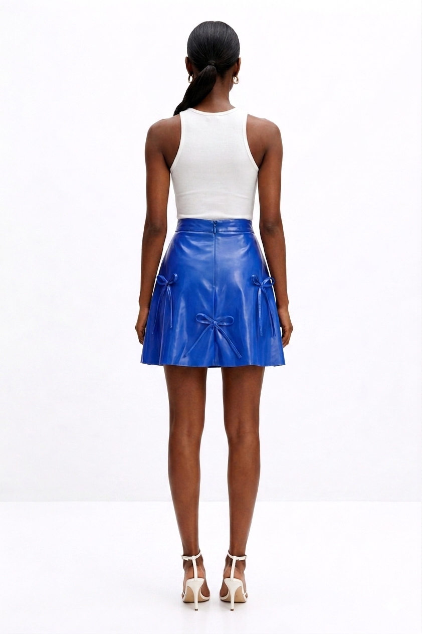 Woman wearing a white top and blue  KINGDOM OF DAUGHTERS skirt on a white background