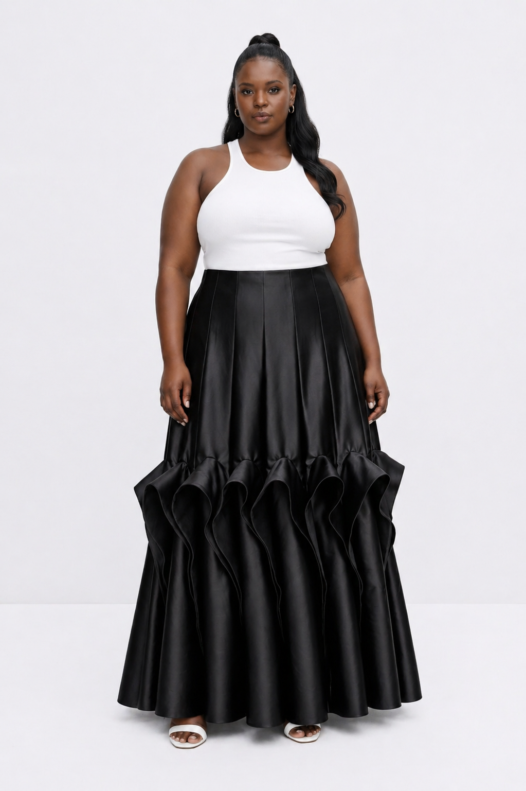 Woman wearing a white top and black ruffled skirt on a white background