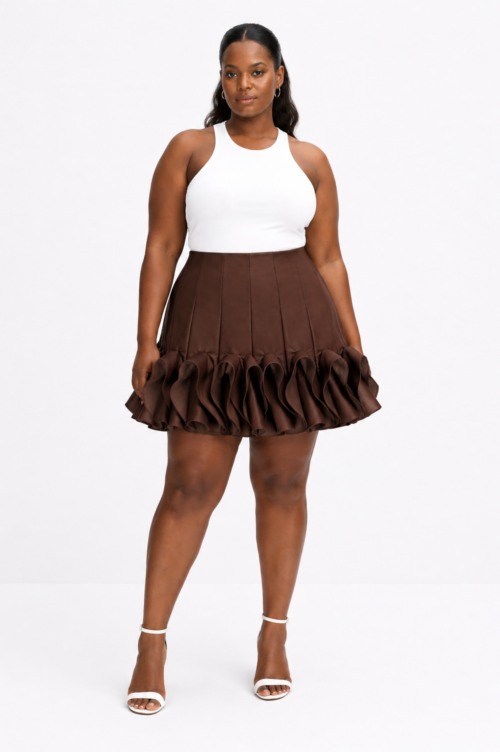 Woman wearing a white top and brown pleated skirt on a white background