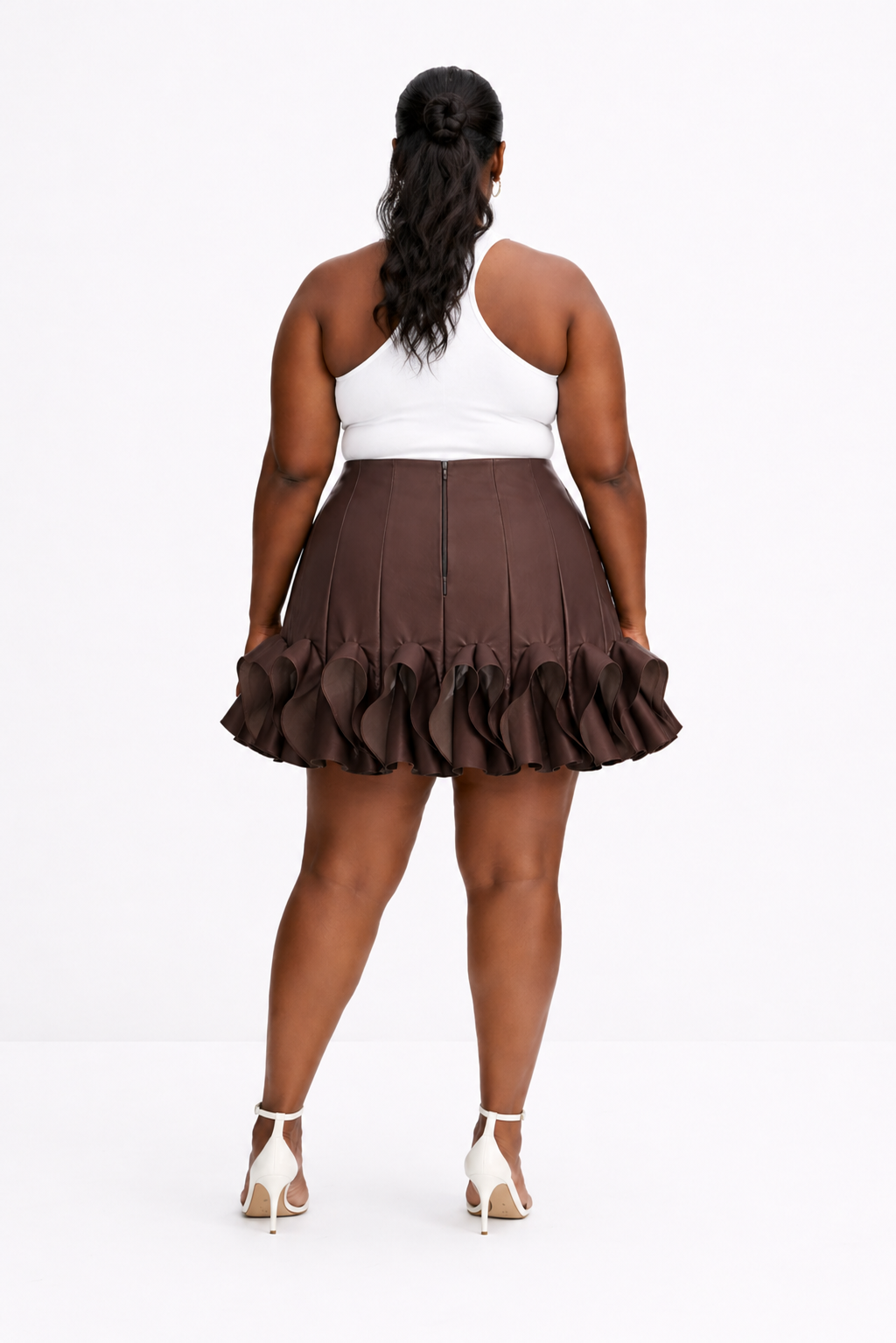 Person wearing a brown ruffled skirt on a white background