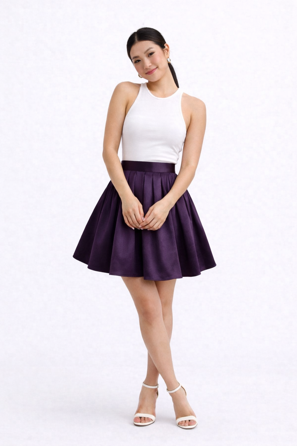 Woman wearing a white top and purple skirt on a white background