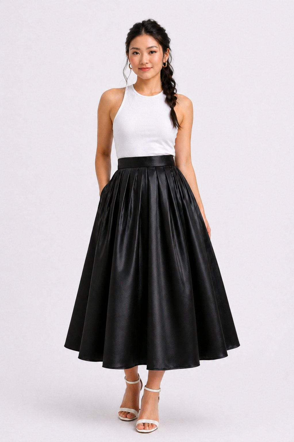 Woman wearing a white top and black leather skirt on a white background