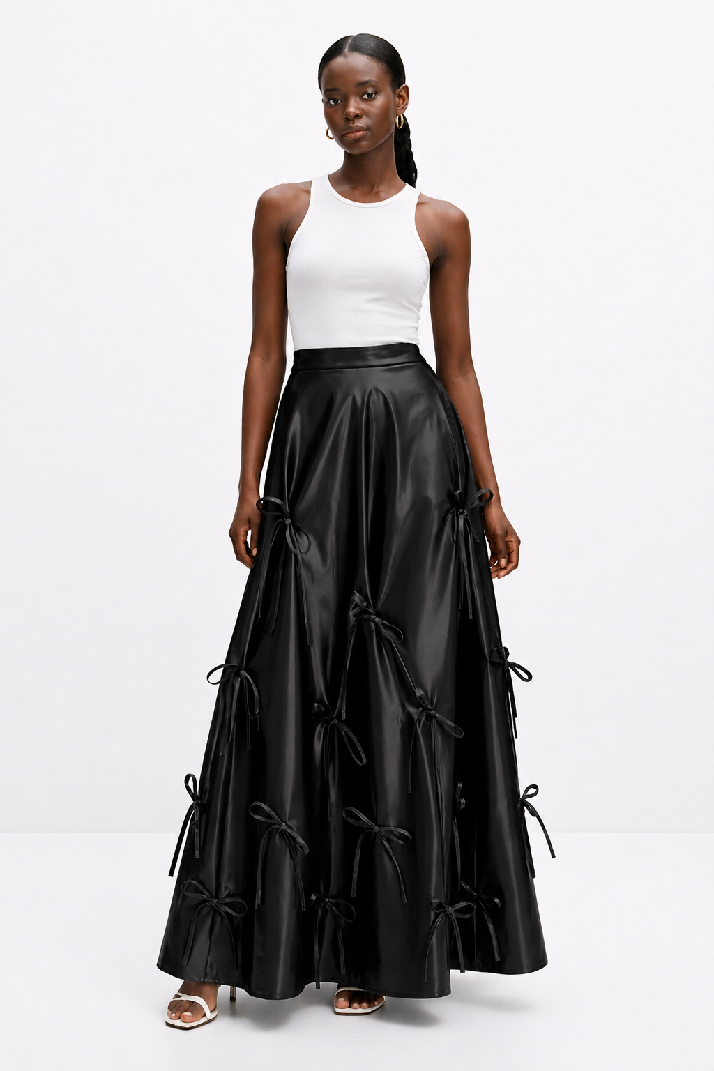 Woman wearing a black leather skirt with white top on a white background