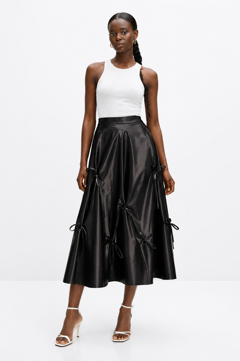Woman wearing a black leather skirt and white top on a white background