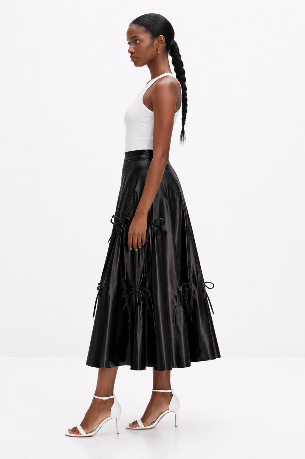 Woman wearing a black leather skirt and white top on a white background