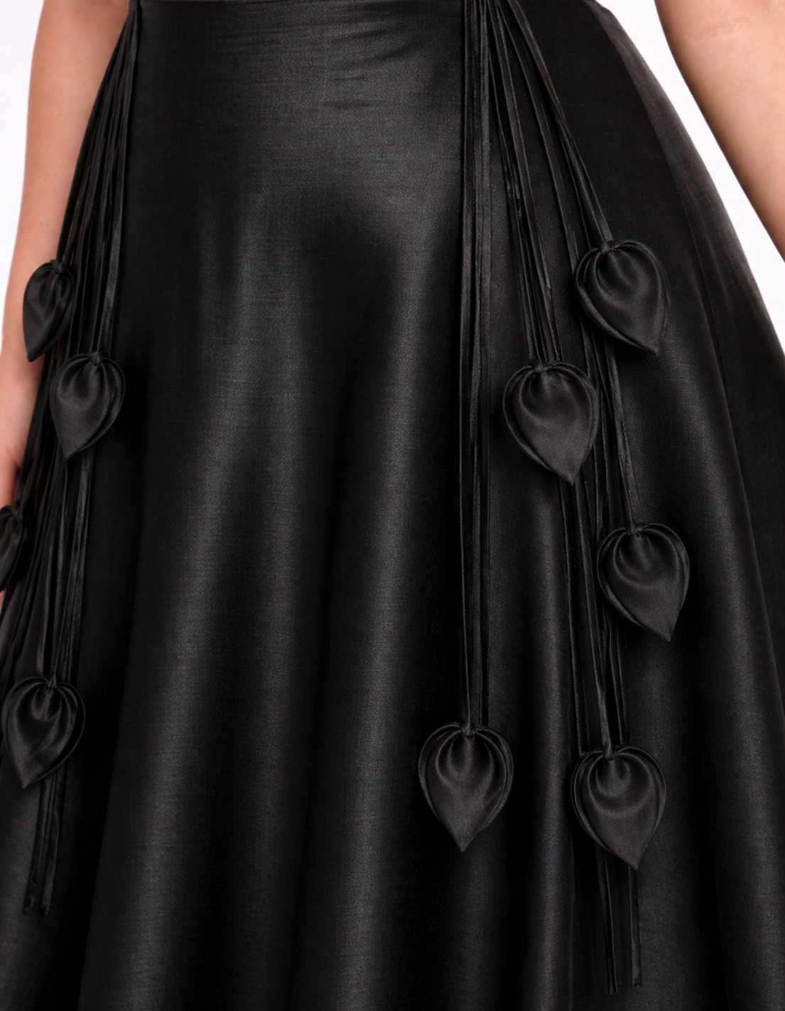 Black dress with decorative elements on a plain background