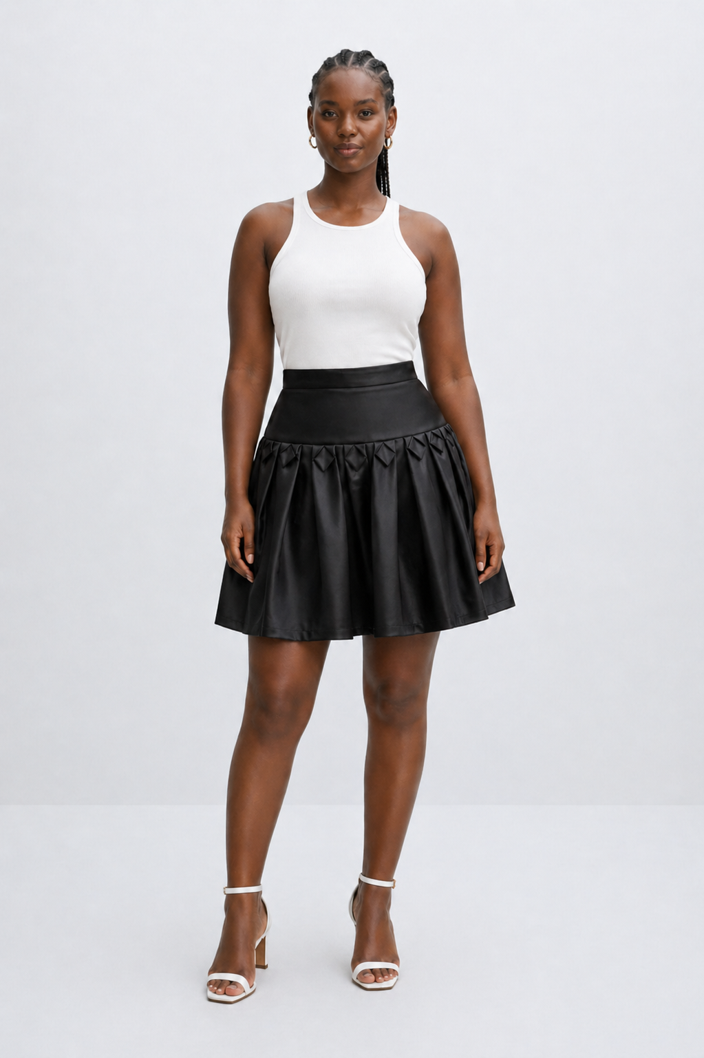 Woman wearing a black leather skirt and white top on a white background