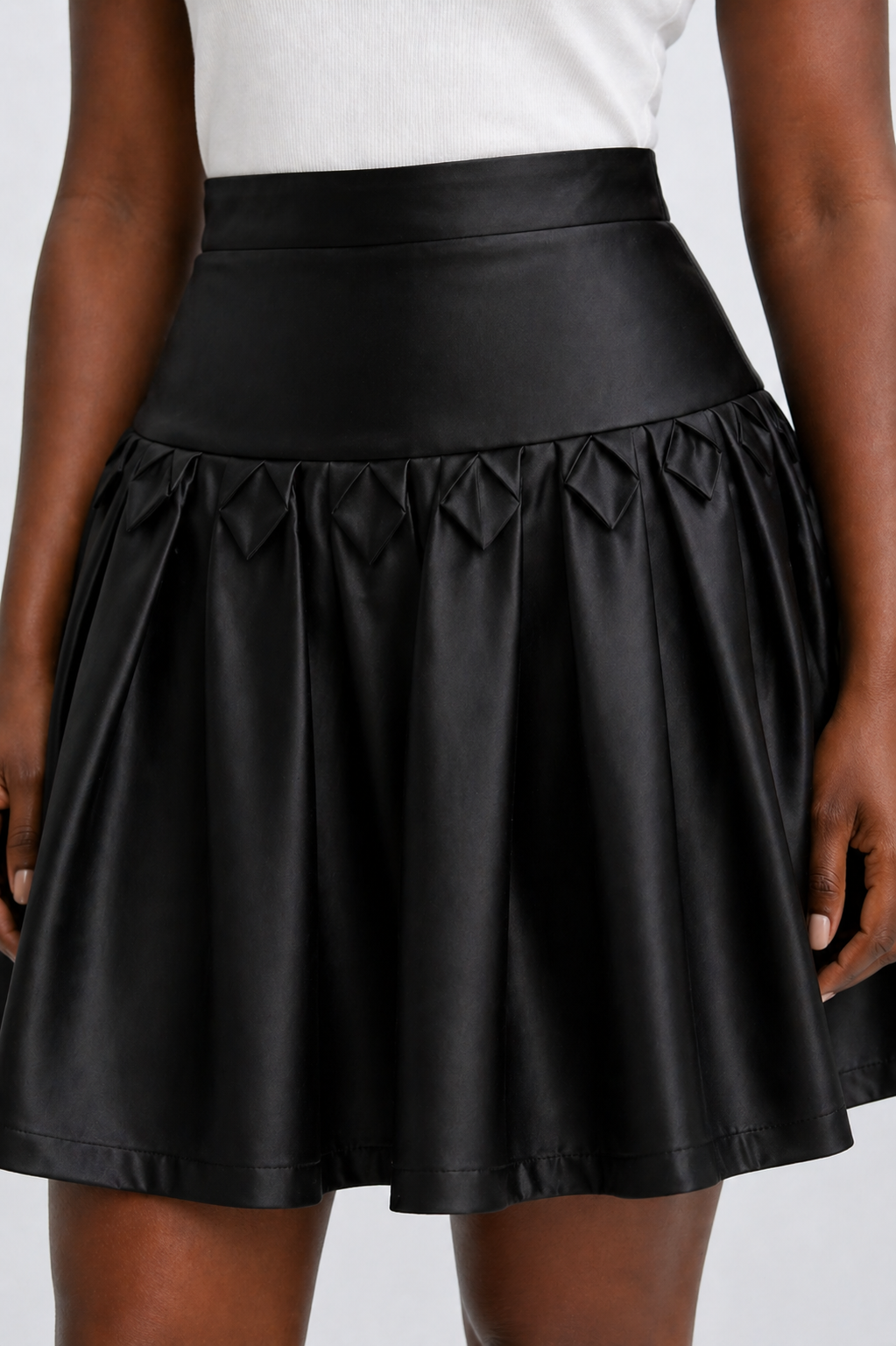 Black skirt worn by a person on a plain background