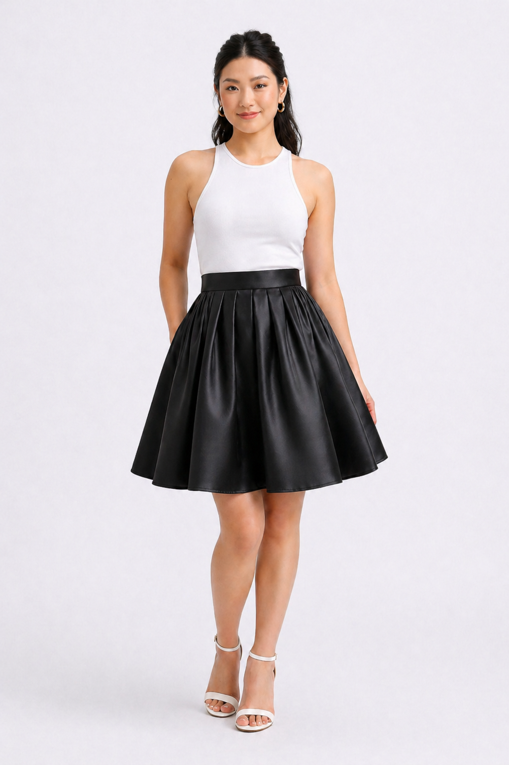 Woman wearing a white top and black leather skirt on a white background
