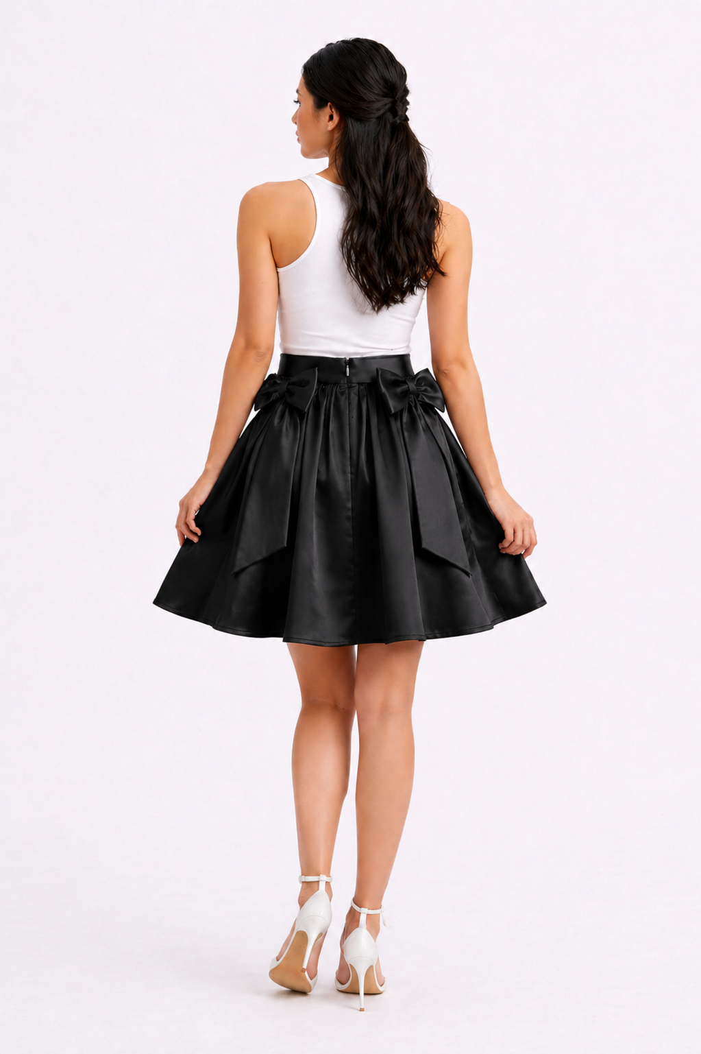 Woman wearing a black skirt with a white top on a white background
