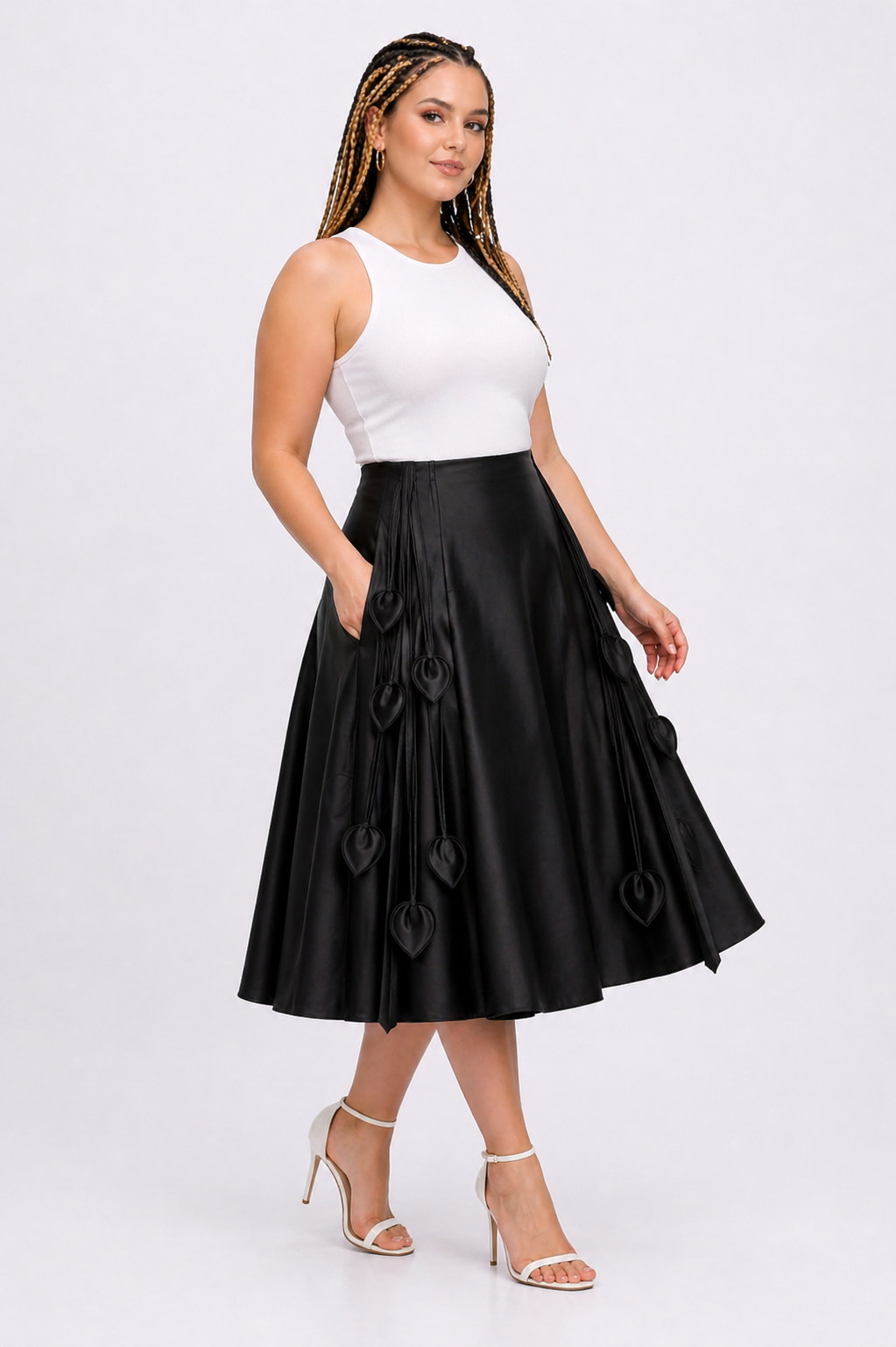 Woman wearing a white sleeveless top and black skirt on a white background