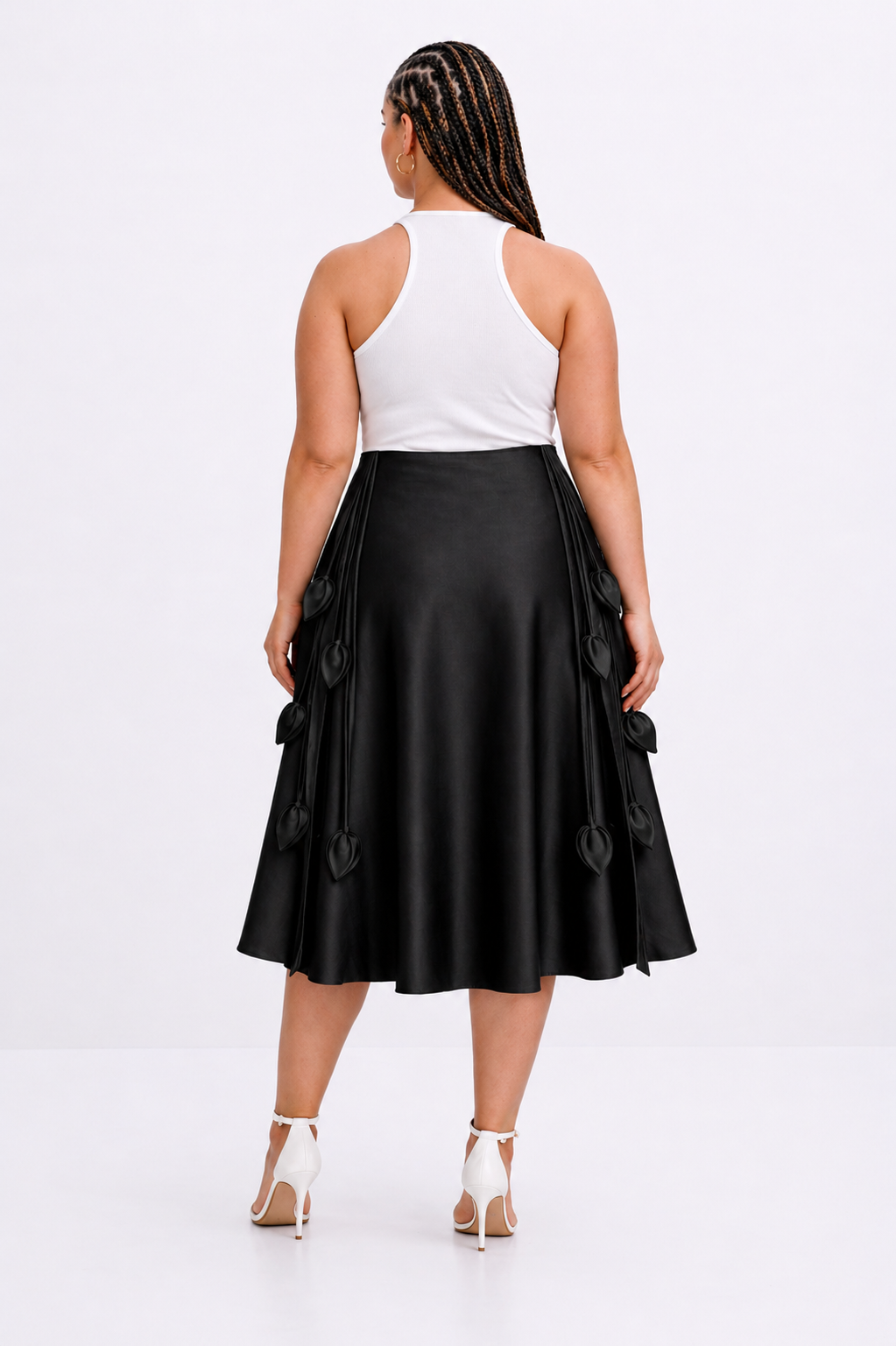 Woman wearing a black skirt with button details on a white background
