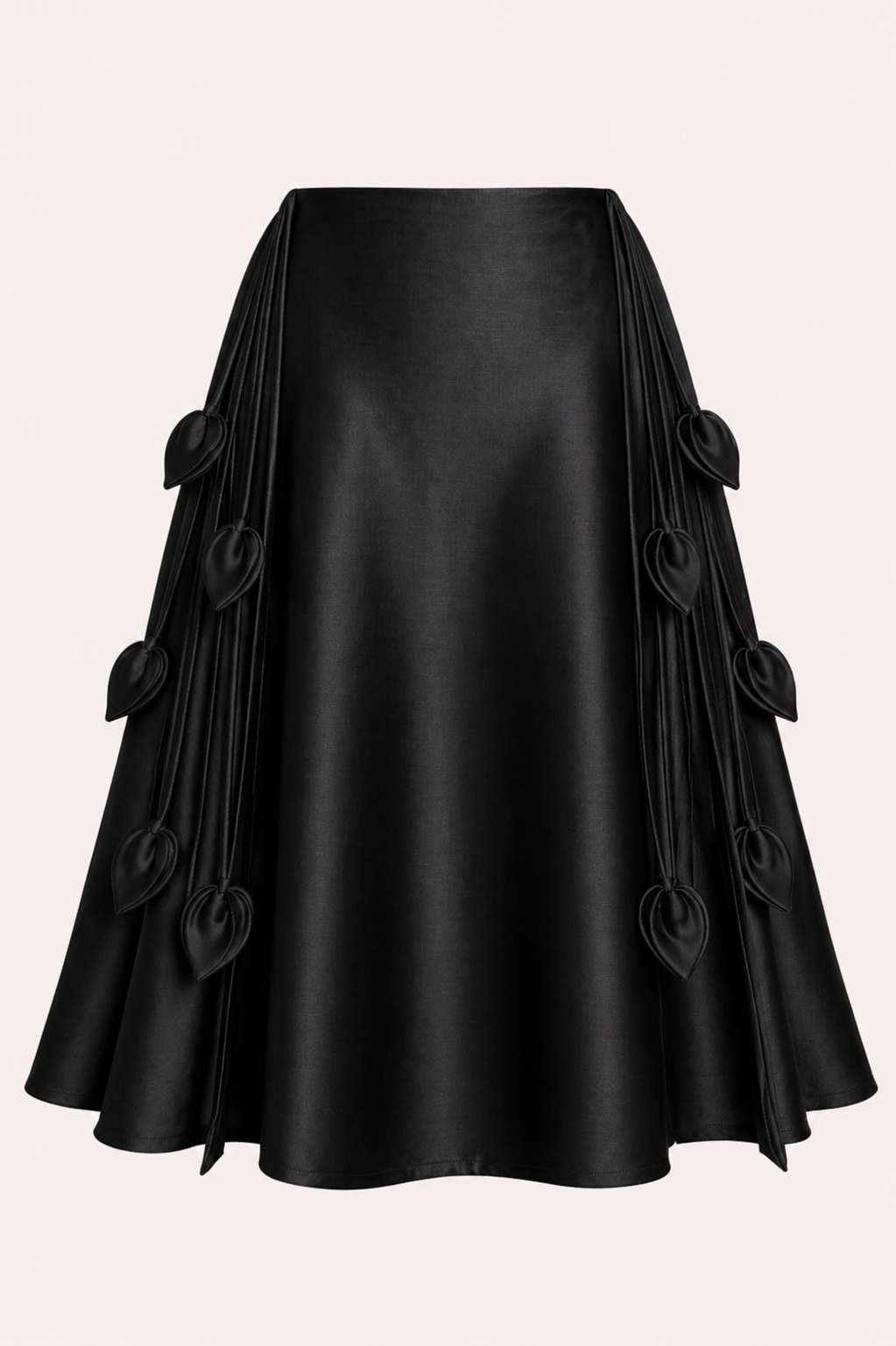 Black satin skirt with decorative buttons on a light pink background