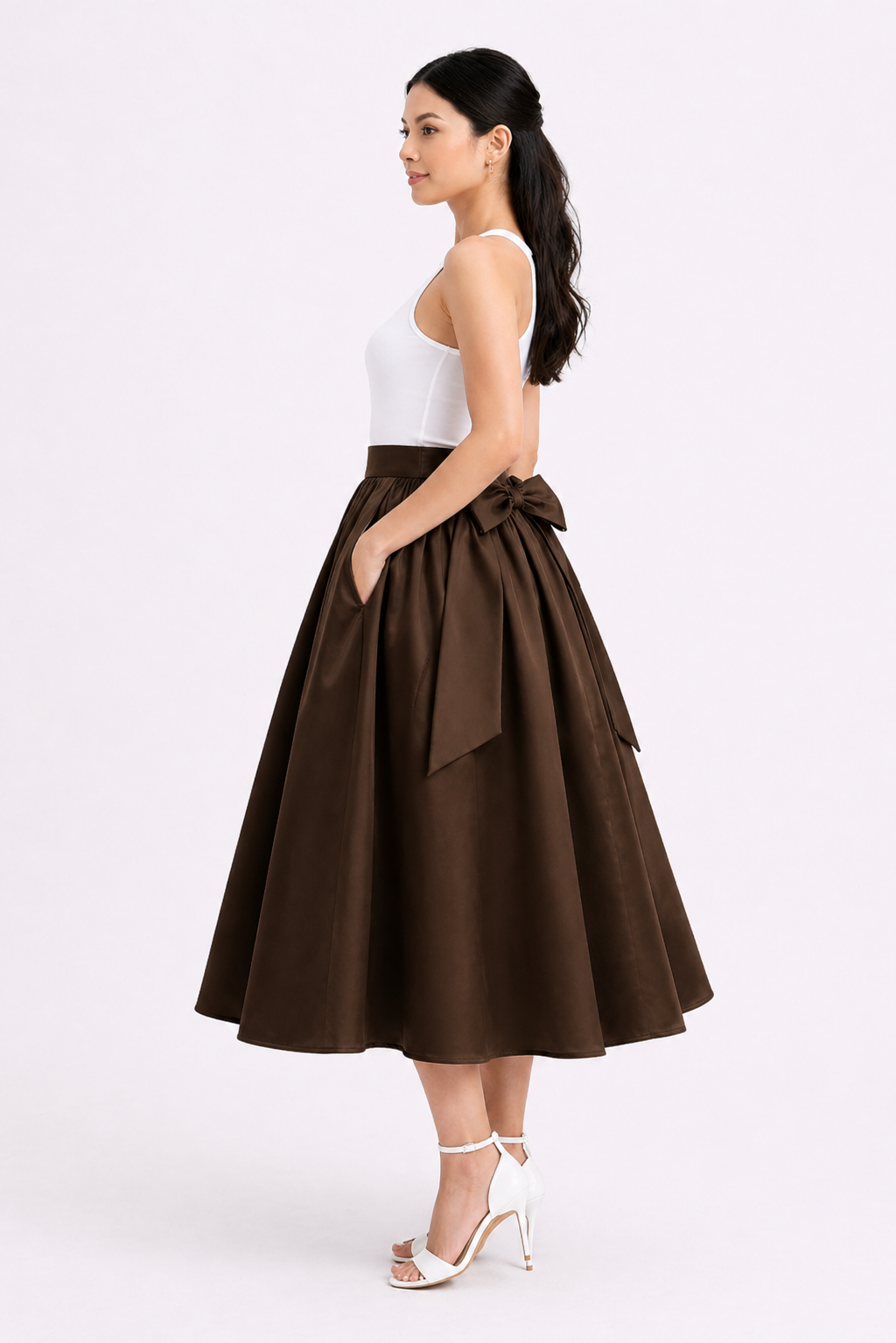 Woman wearing a brown skirt with a white top on a white background