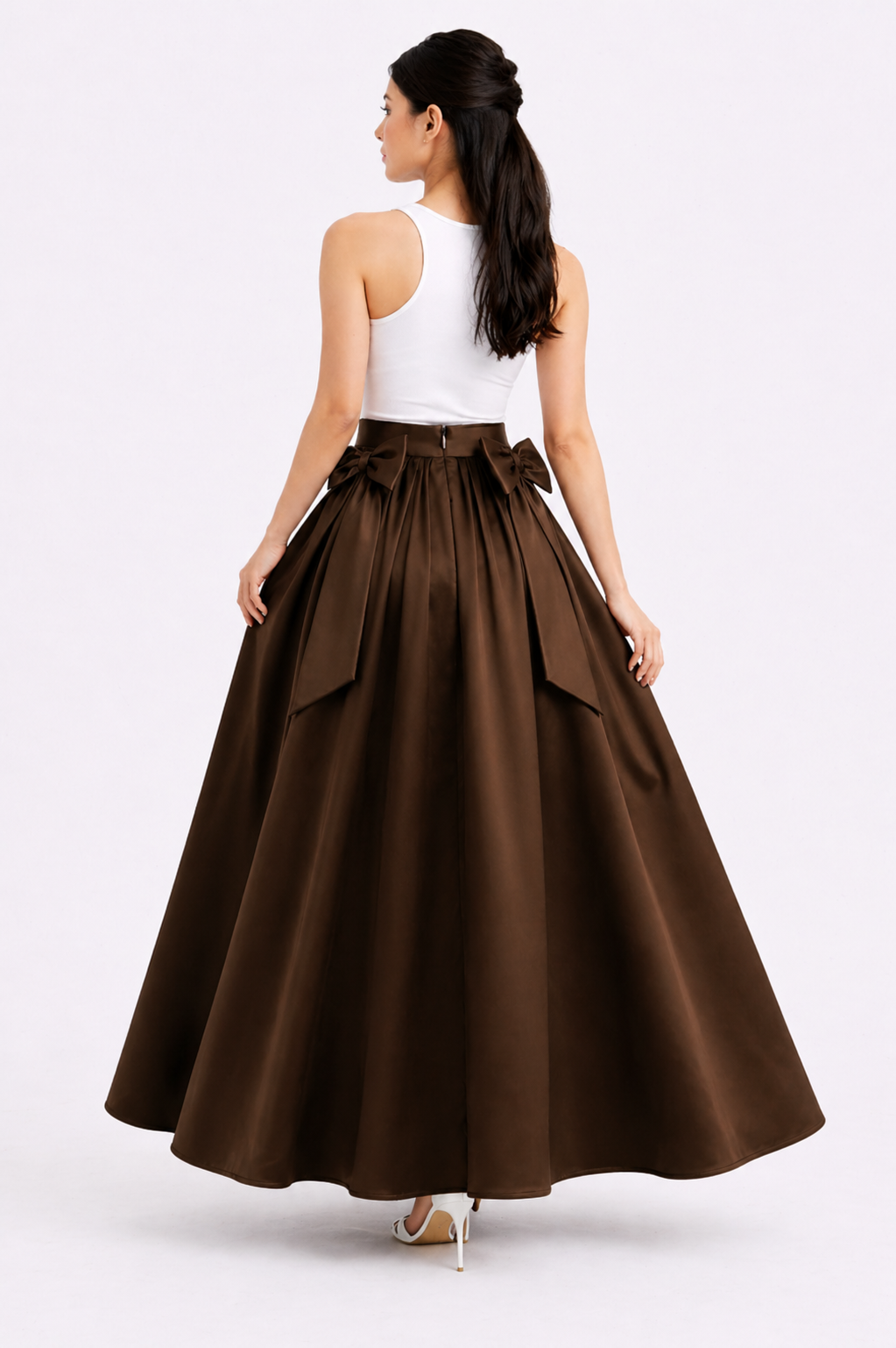 Woman wearing a brown full skirt with a white top on a white background