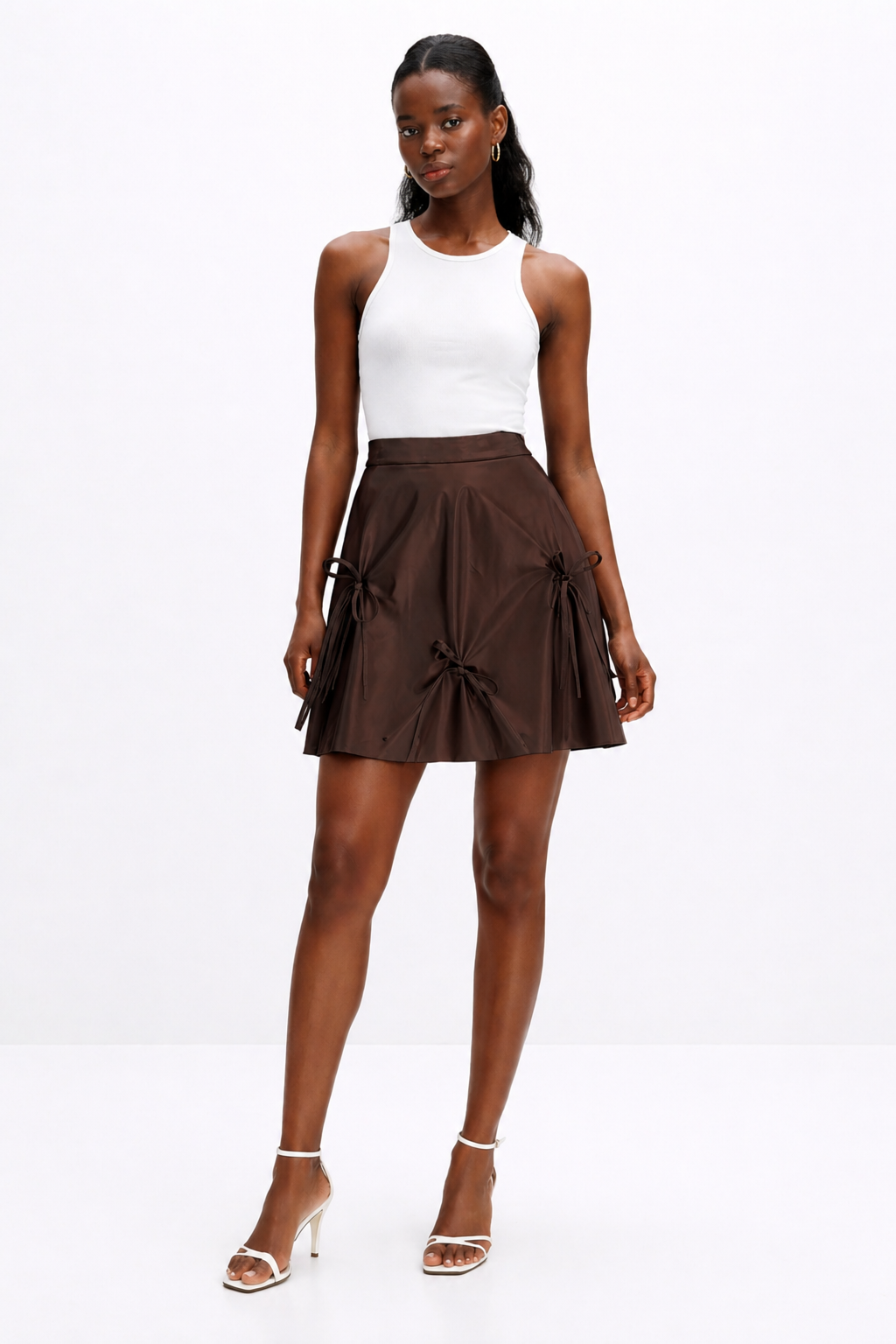 Woman wearing a white top and brown skirt on a white background