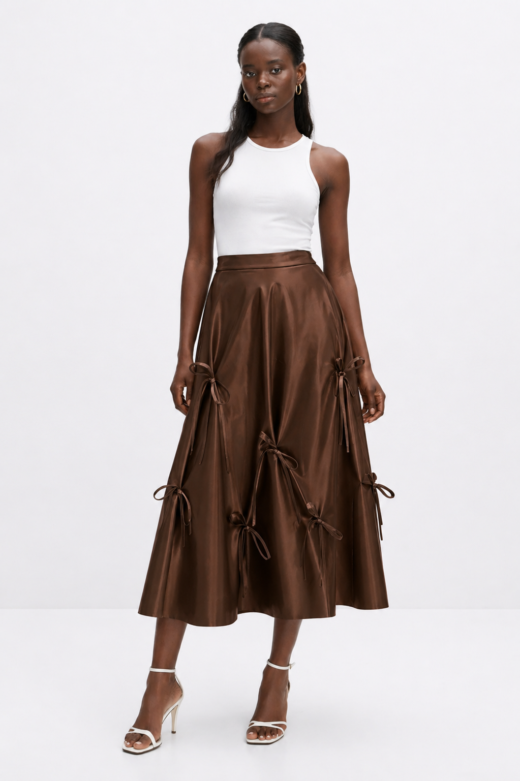 Woman wearing a white top and brown leather skirt on a white background