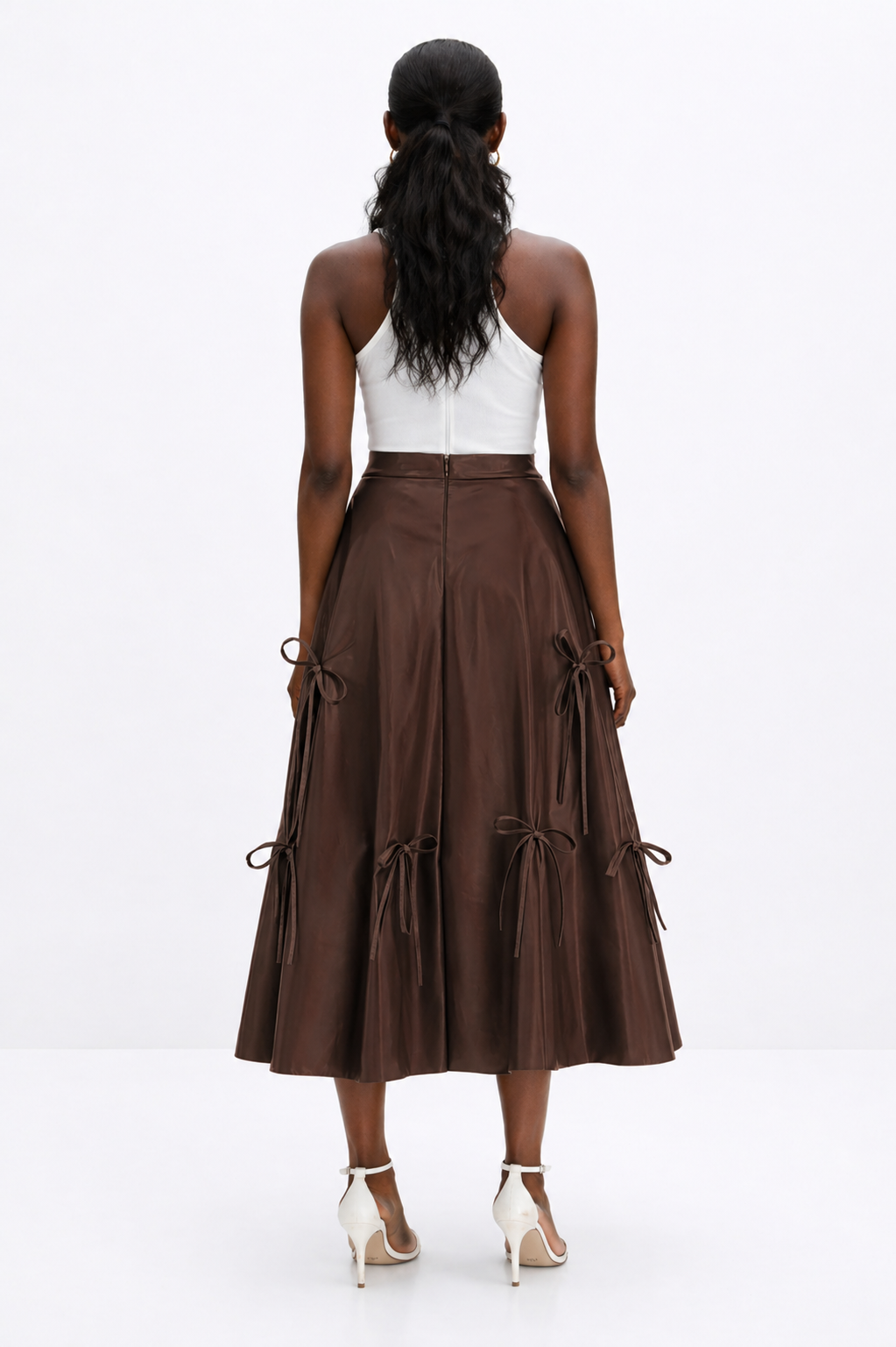 Woman wearing a brown skirt with tied ribbons on a white background