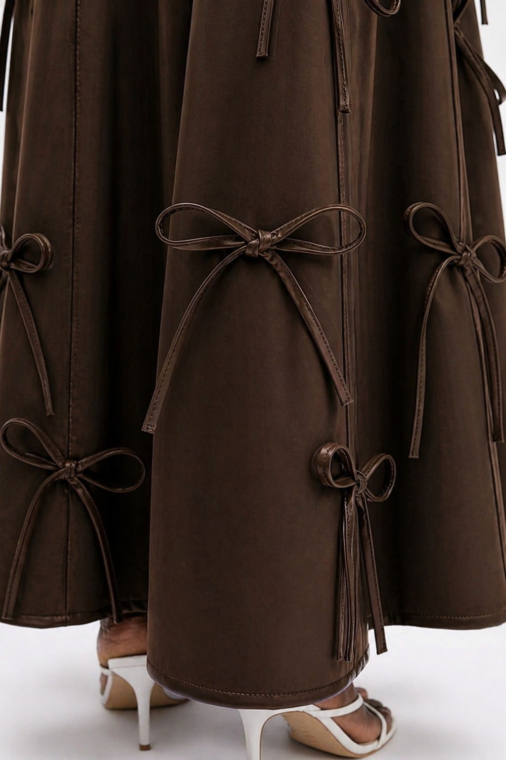 Brown coat with bow details on a white background