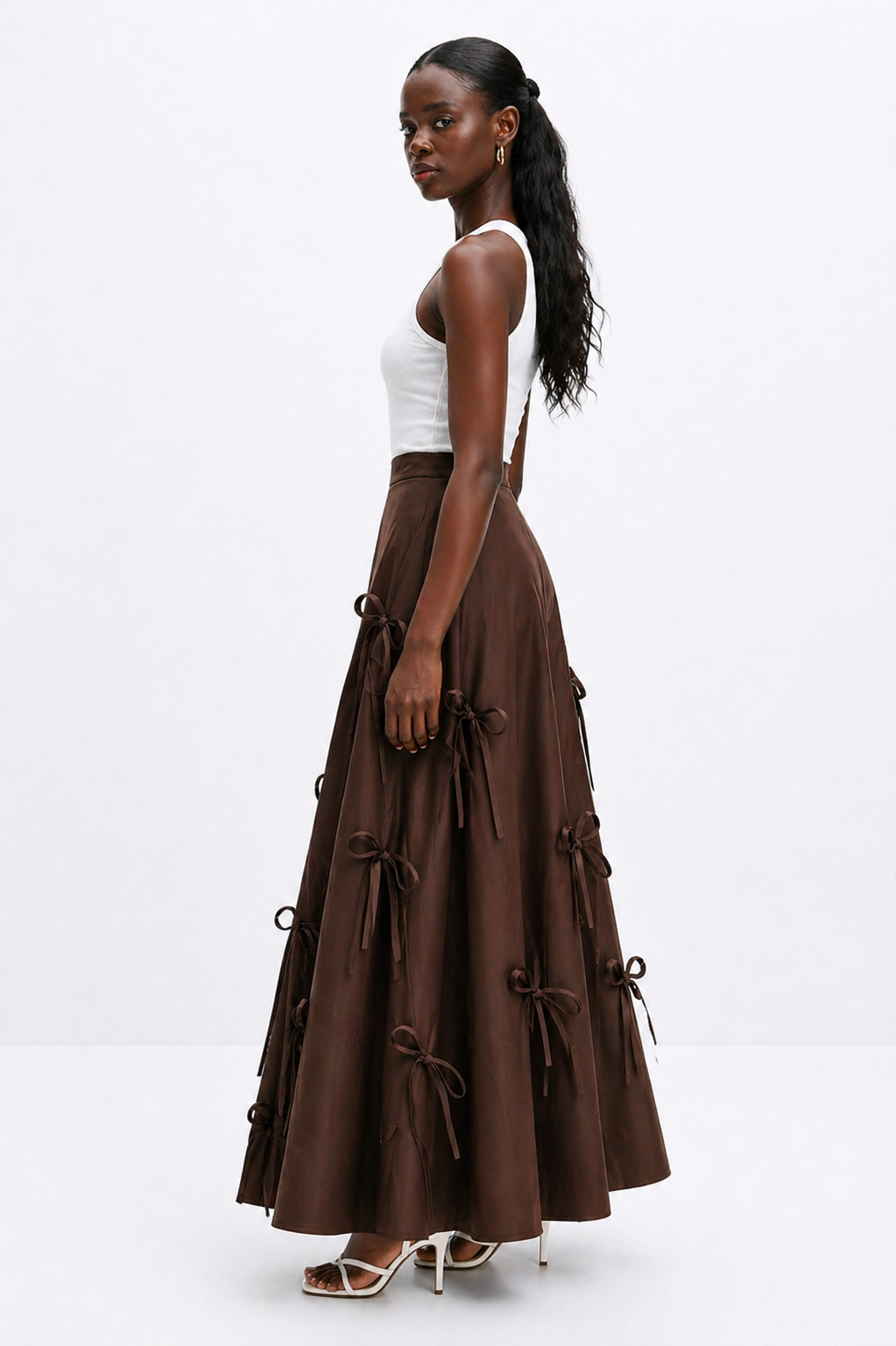 Woman wearing a brown dress with suspenders on a white background