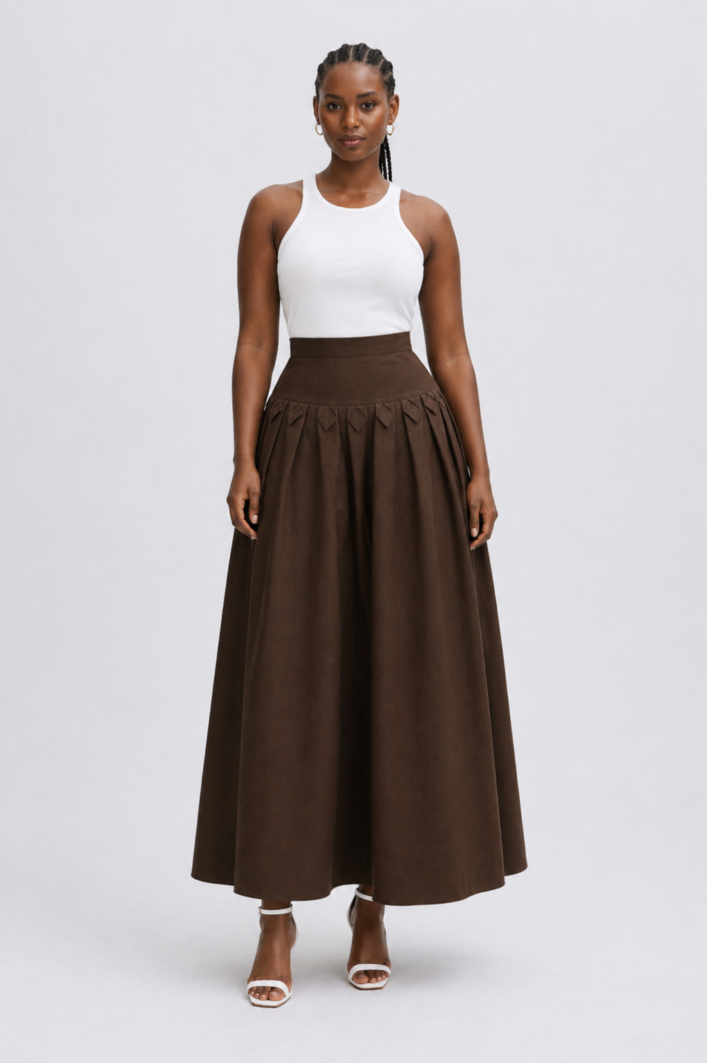 Woman wearing a white top and brown skirt on a white background