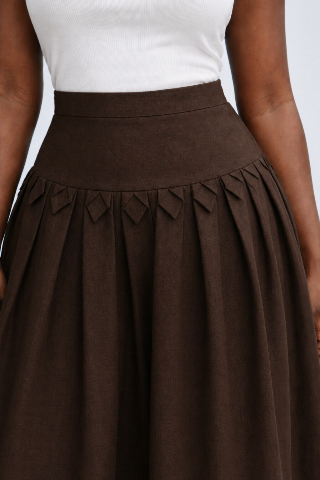 Brown skirt with a white top on a neutral background