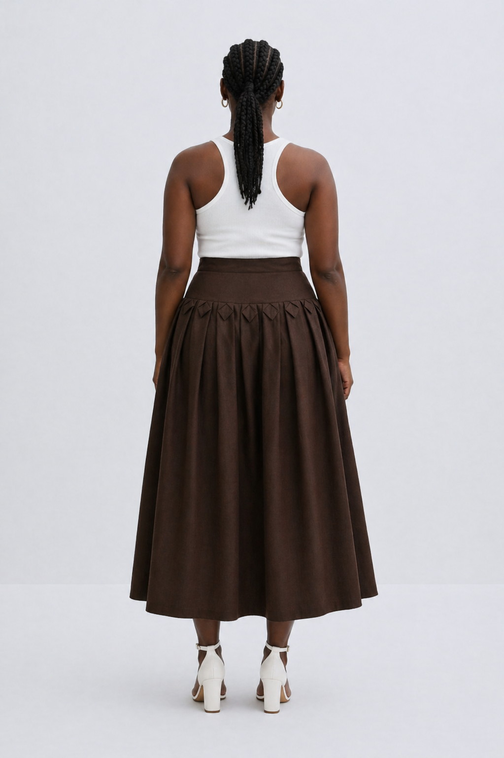 Person wearing a white top and brown skirt on a white background