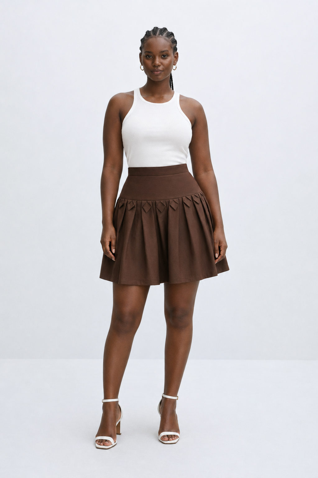 Woman wearing a white top and brown skirt on a white background