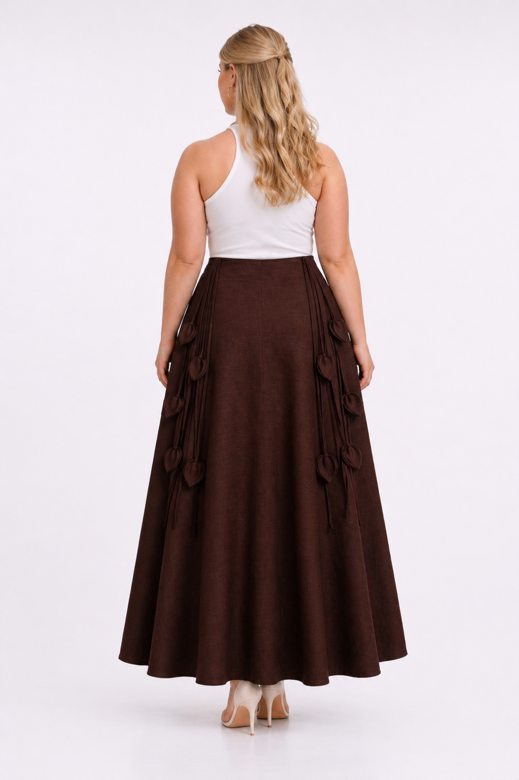 Woman wearing a white top and brown skirt on a white background