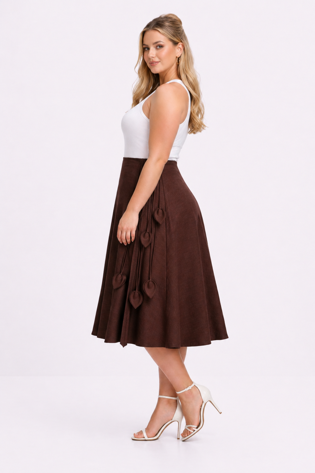 Woman wearing a white top and brown skirt on a white background