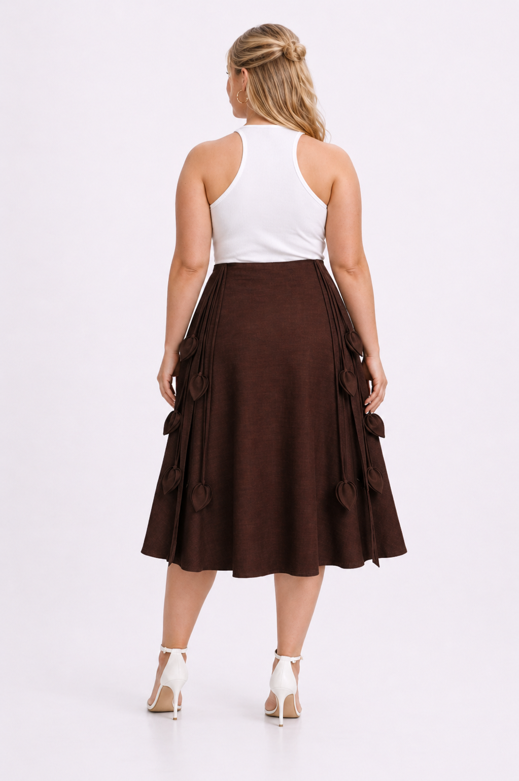 Woman wearing a white top and brown skirt on a white background