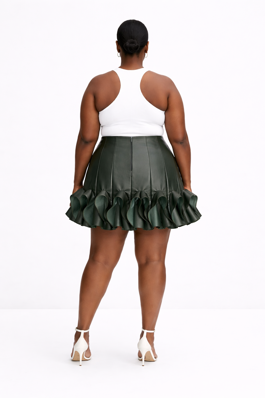 Woman wearing a white top and green kingdom of daughters pleated skirt on a white background