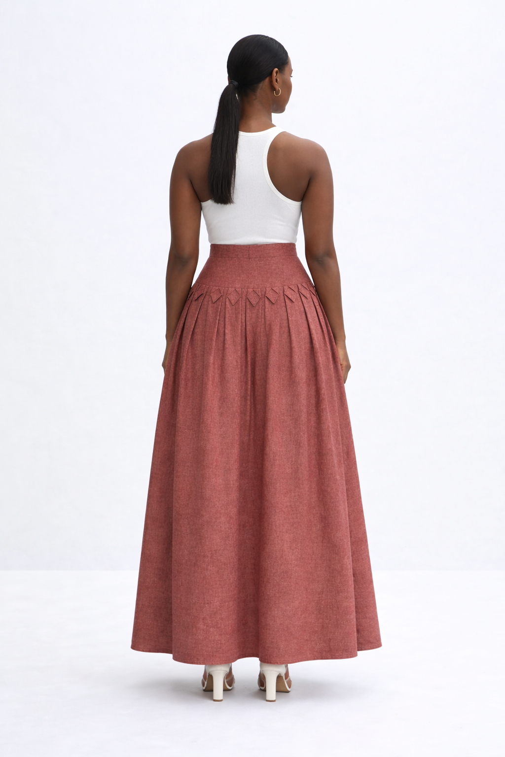 woman with white top and brick red kingdom of daughters skirt
