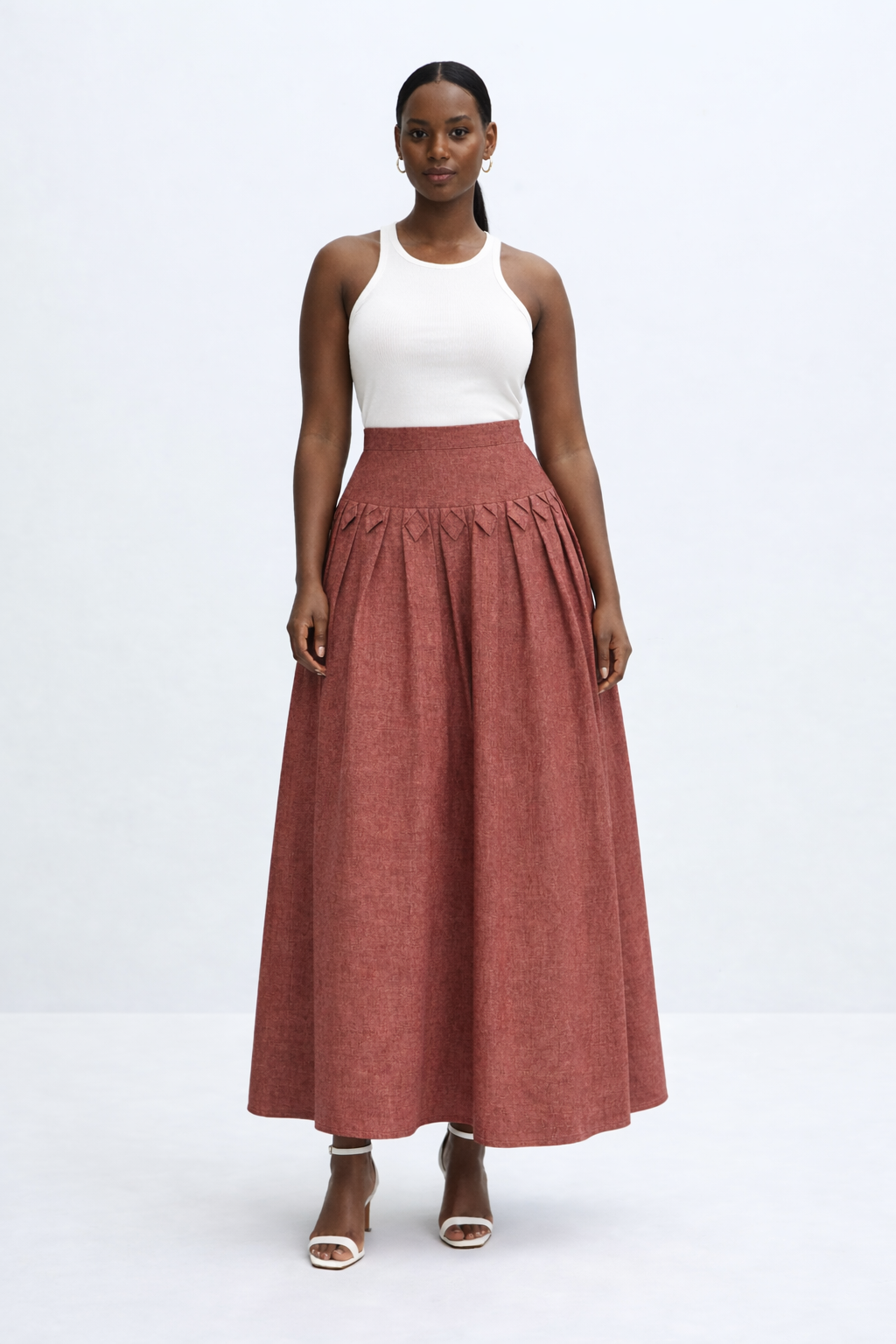 woman with white top and brick red kingdom of daughters skirt