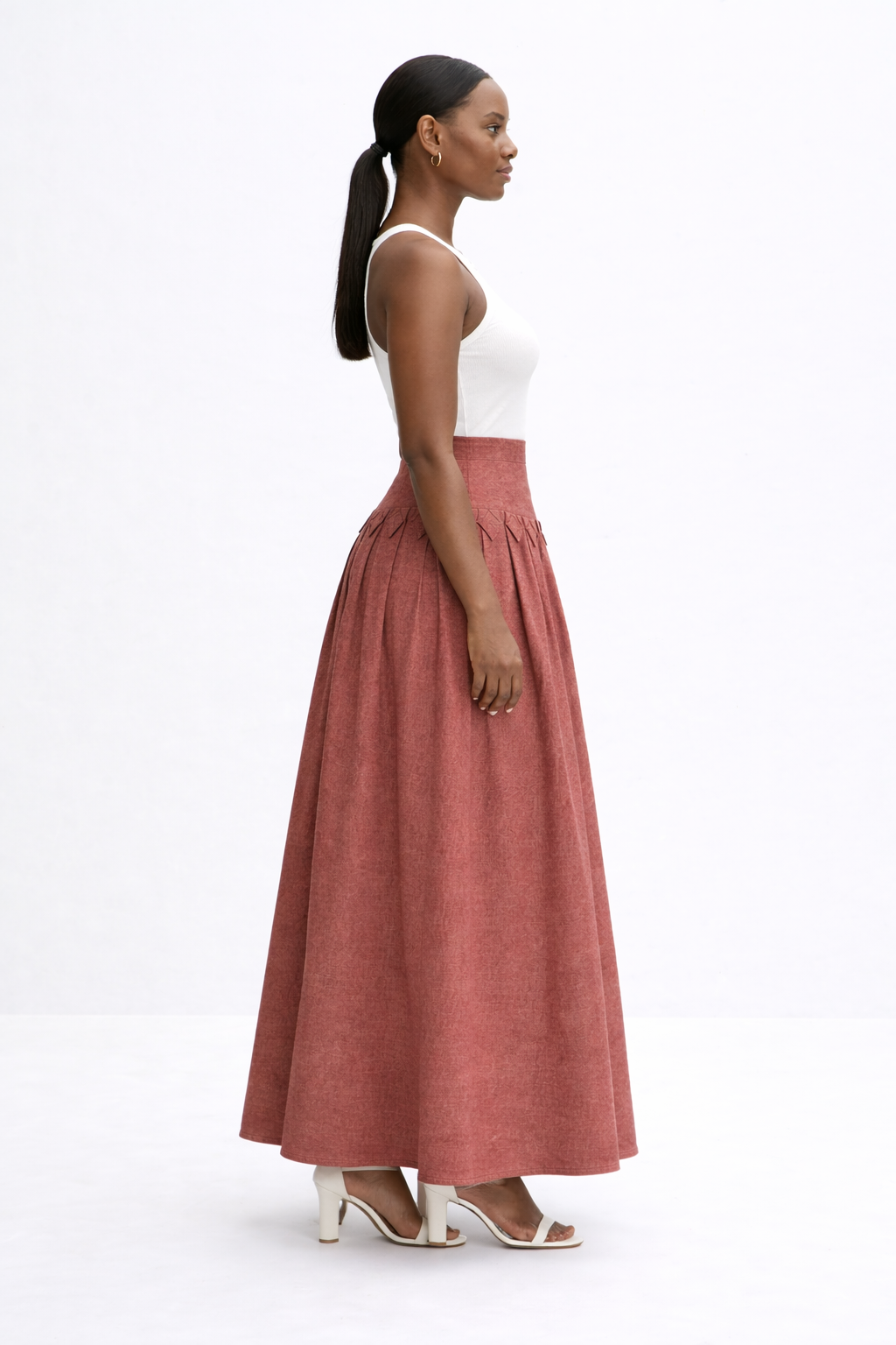 woman with white top and brick red kingdom of daughters skirt