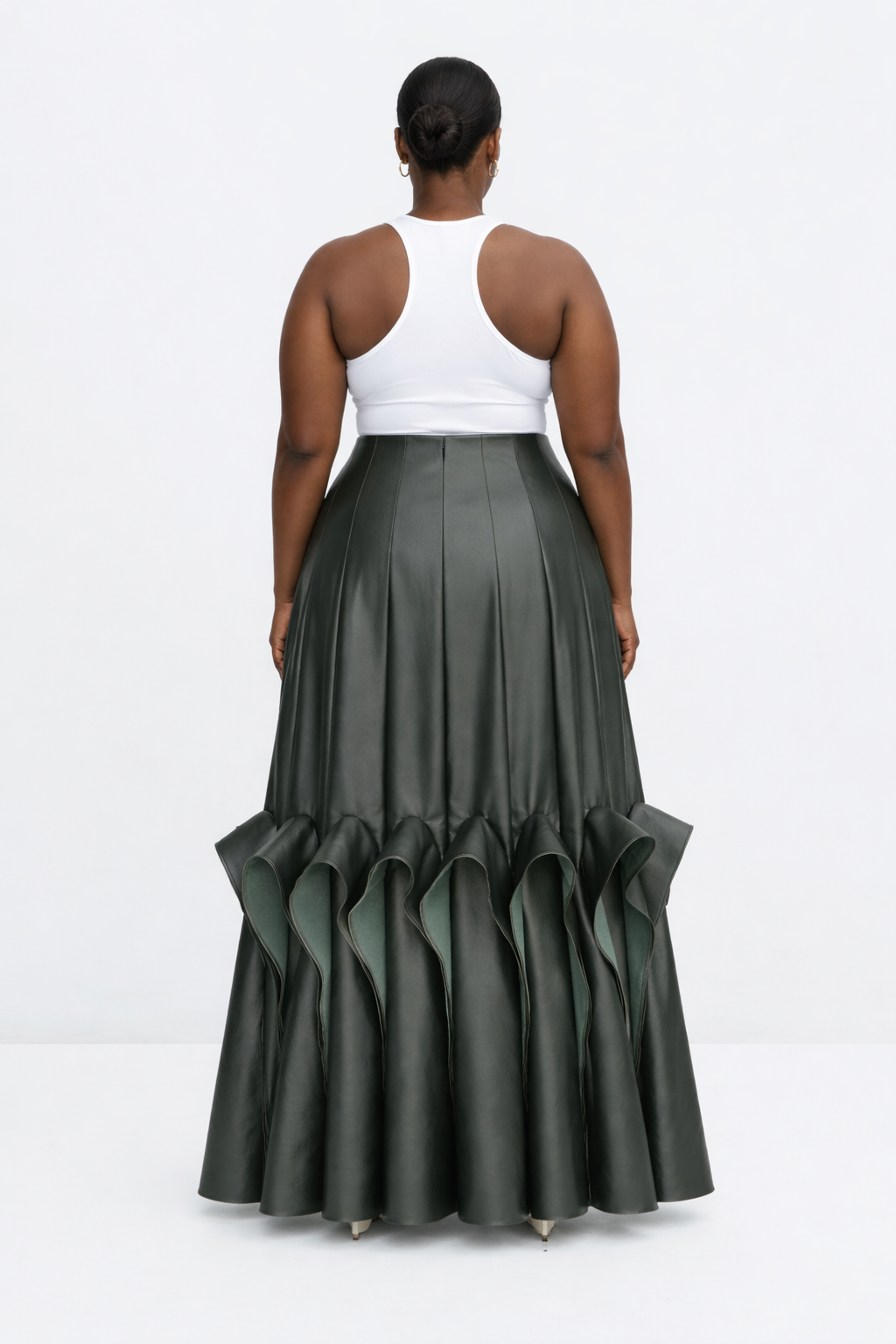 Woman wearing a white top and green ruffled kingdom of daughters skirt on a white background