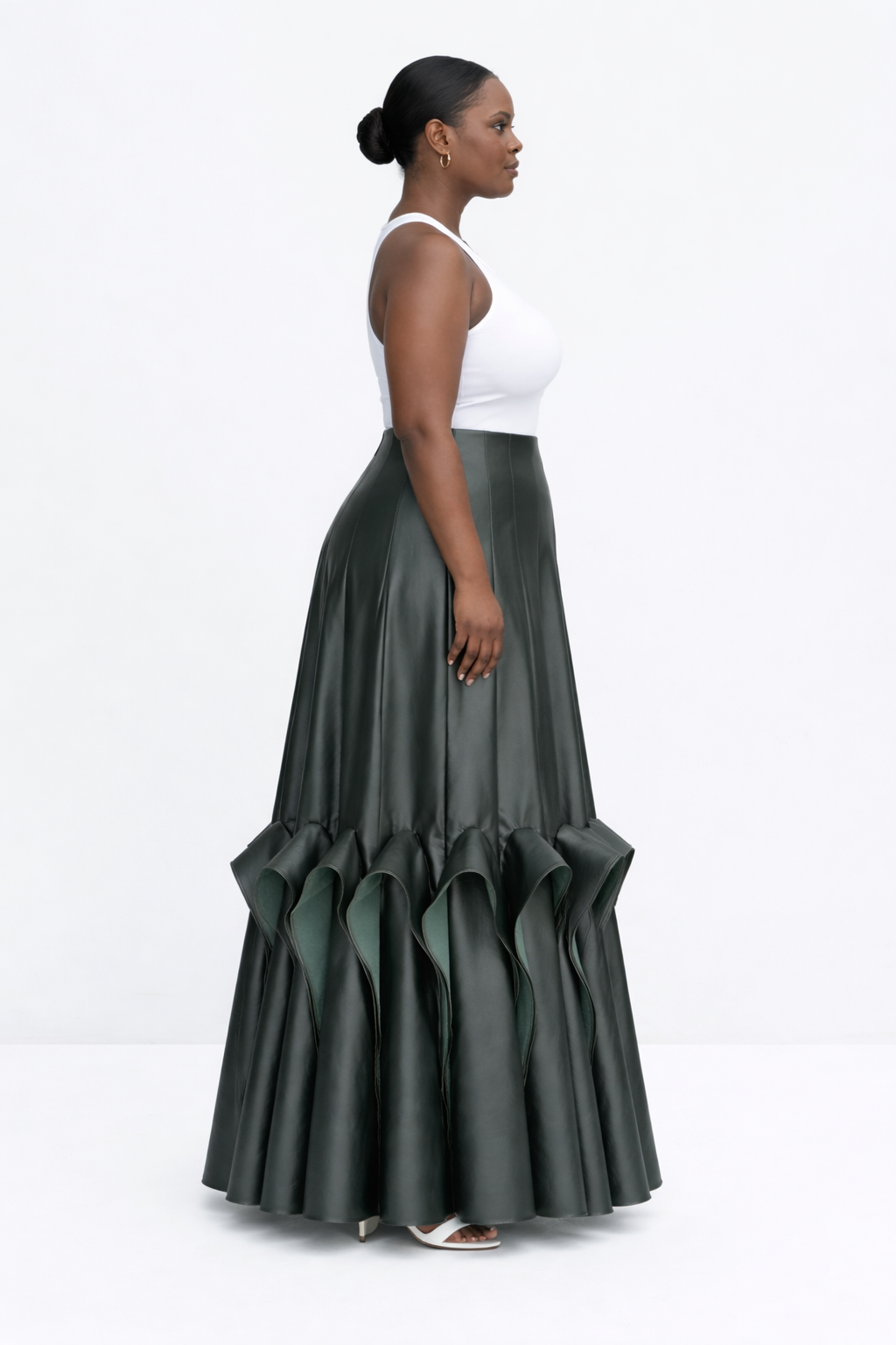 Woman wearing a white top and green ruffled kingdom of daughters skirt on a white background