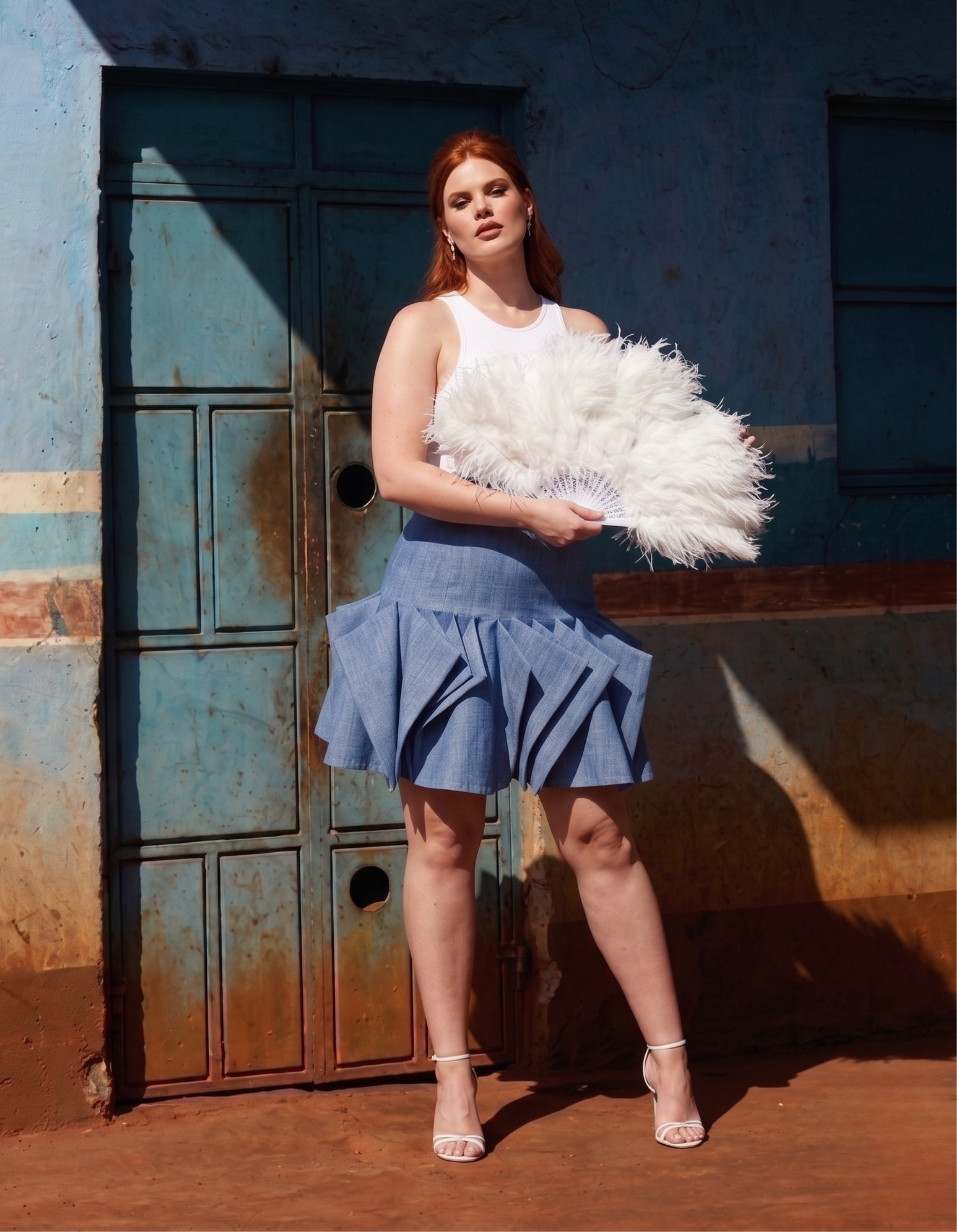 Woman holding a white feathered object in front of a textured wall.