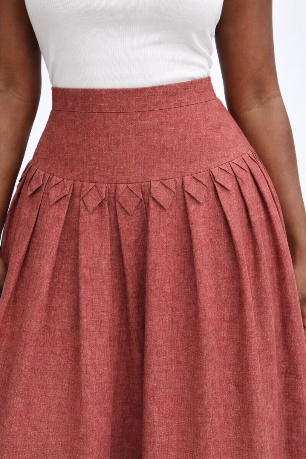 woman with white top and brick red kingdom of daughters skirt