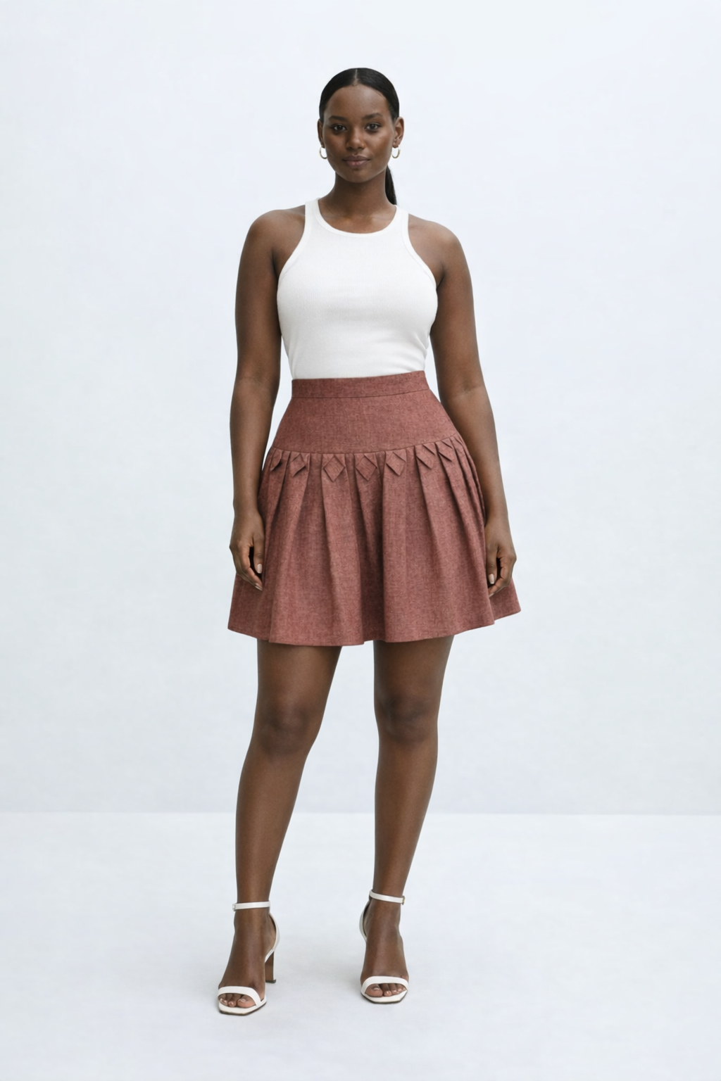 Woman wearing a white top and brown kingdom of daughters skirt on a white background