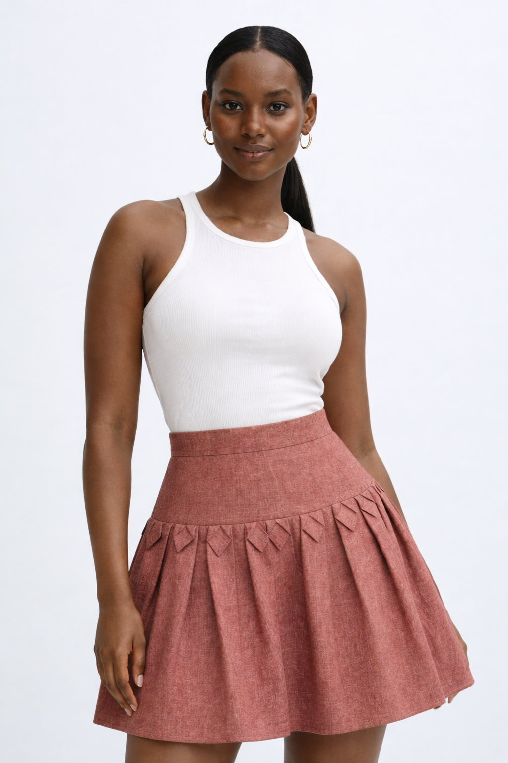 Woman wearing a white top and brown kingdom of daughters skirt on a white background