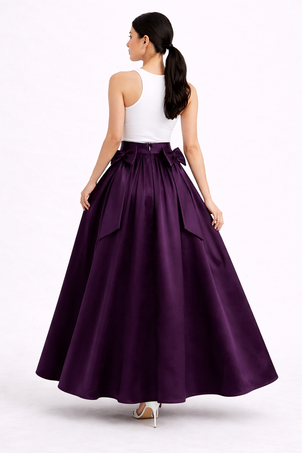 Woman wearing a white top and purple skirt on a white background