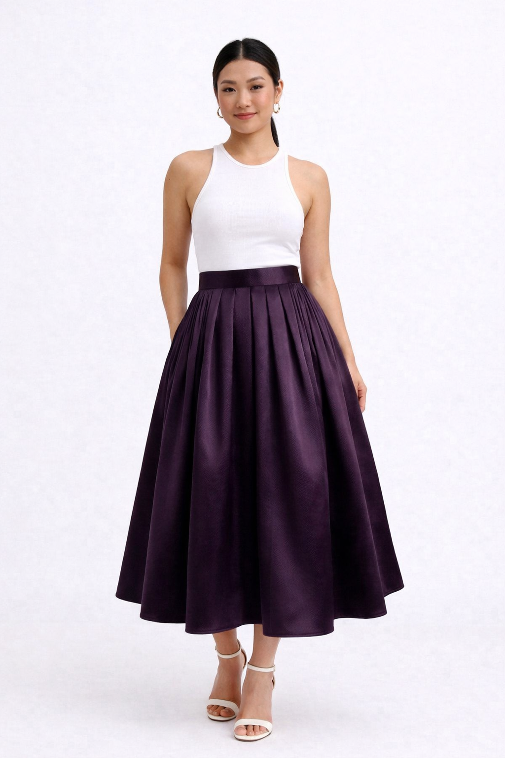 Woman wearing a white top and purple skirt on a white background