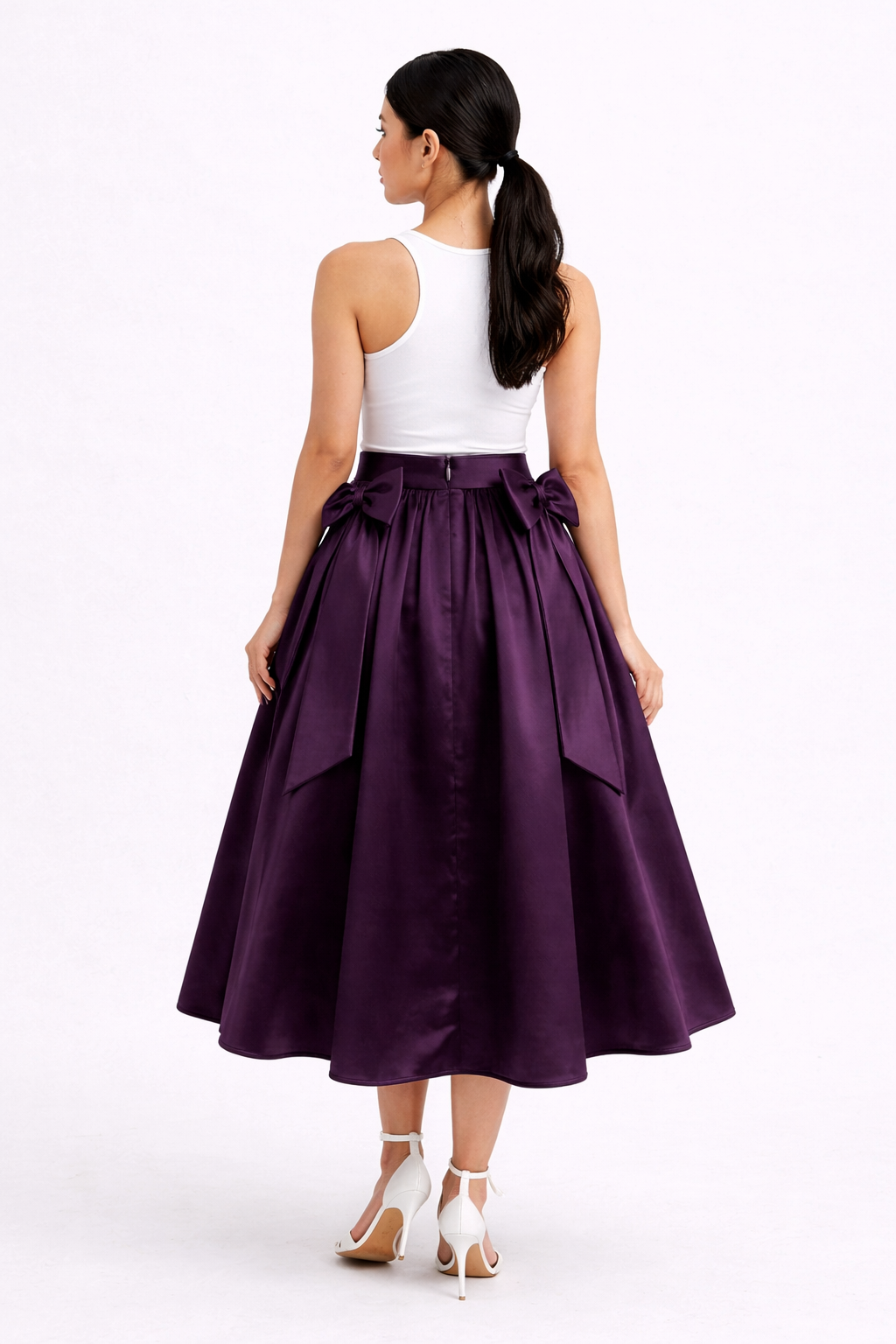 Woman wearing a white top and purple skirt on a white background