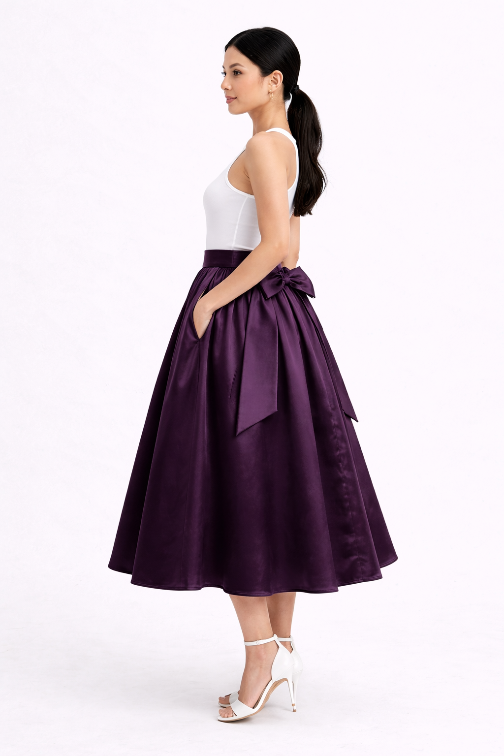 Woman wearing a purple skirt with a white top on a white background